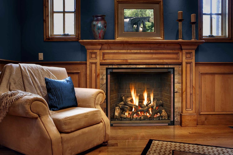 シアトルにある高級な広いトラディショナルスタイルのおしゃれなオープンリビング (標準型暖炉、木材の暖炉まわり、青い壁、無垢フローリング、茶色い床) の写真