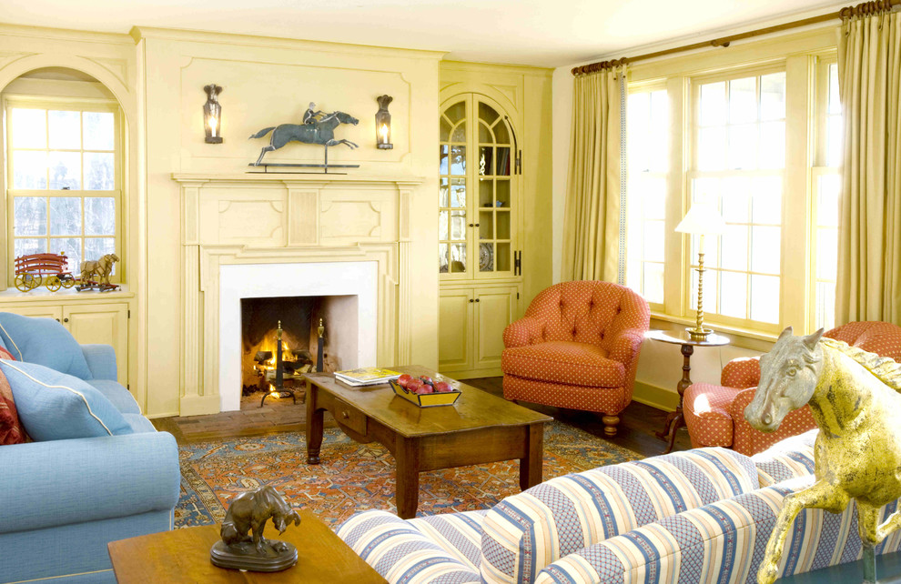 Cette image montre une grande salle de séjour traditionnelle fermée avec un mur jaune, moquette, une cheminée standard et un manteau de cheminée en béton.
