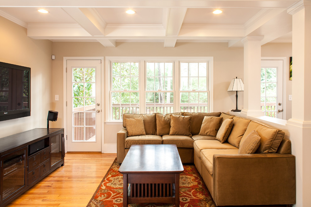 Ispirazione per un soggiorno classico con pareti beige, pavimento in legno massello medio e TV a parete