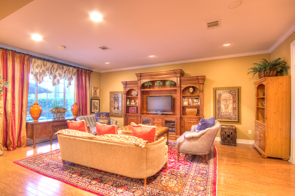 Стильный дизайн: открытая гостиная комната среднего размера в классическом стиле с желтыми стенами, полом из ламината и отдельно стоящим телевизором - последний тренд