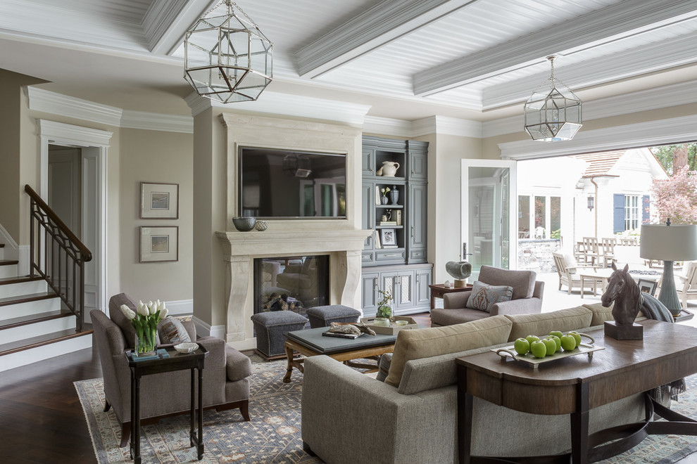 Immagine di un soggiorno classico con pareti beige, parquet scuro, camino classico, TV a parete, pavimento marrone e tappeto