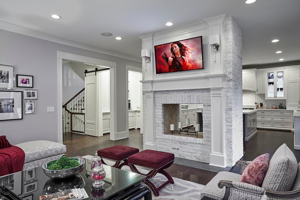 Medium sized traditional open plan games room in Chicago with purple walls, dark hardwood flooring, a two-sided fireplace, a brick fireplace surround, a wall mounted tv and brown floors.
