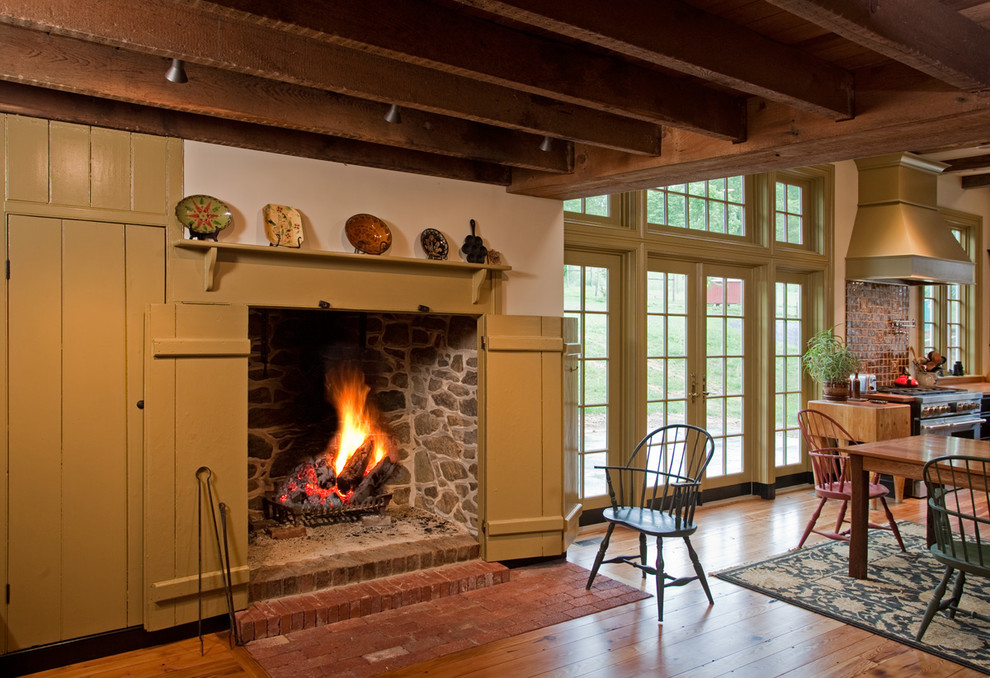 Aménagement d'une salle de séjour campagne de taille moyenne et ouverte avec un mur blanc, un sol en bois brun, une cheminée standard, un manteau de cheminée en plâtre et un sol marron.