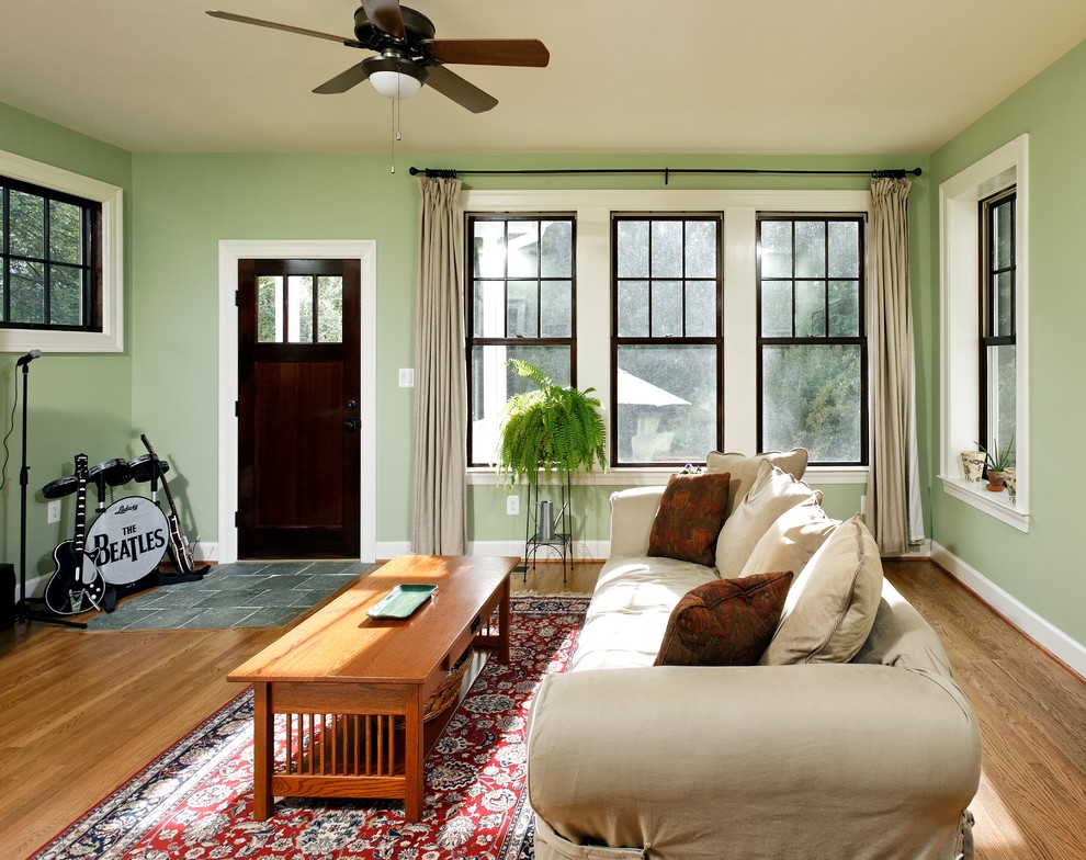 Example of a mid-sized tuscan enclosed medium tone wood floor family room design in DC Metro with green walls