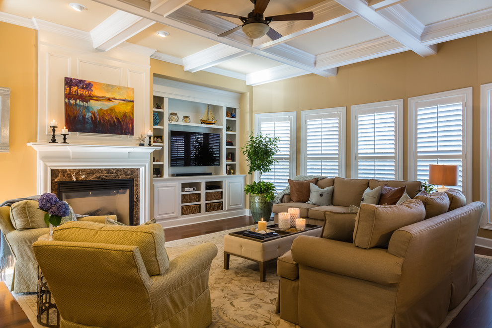 Ejemplo de sala de estar abierta tradicional renovada grande con paredes beige, suelo de madera en tonos medios, todas las chimeneas, marco de chimenea de baldosas y/o azulejos y pared multimedia