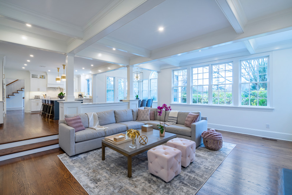 Large transitional open concept dark wood floor, brown floor and coffered ceiling family room photo in Philadelphia with a standard fireplace, a wood fireplace surround, a wall-mounted tv and white walls