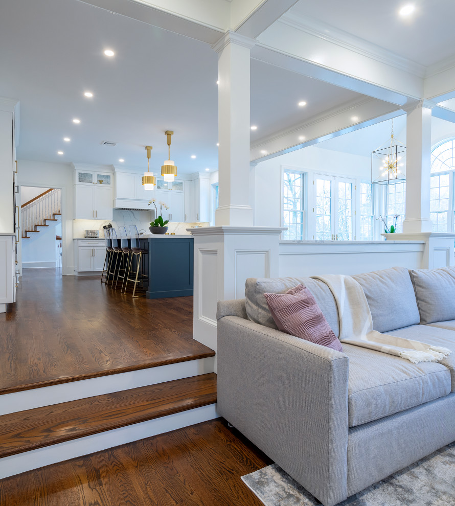 Large classic open plan games room in Philadelphia with white walls, dark hardwood flooring, a standard fireplace, a wooden fireplace surround, a wall mounted tv, brown floors and a coffered ceiling.