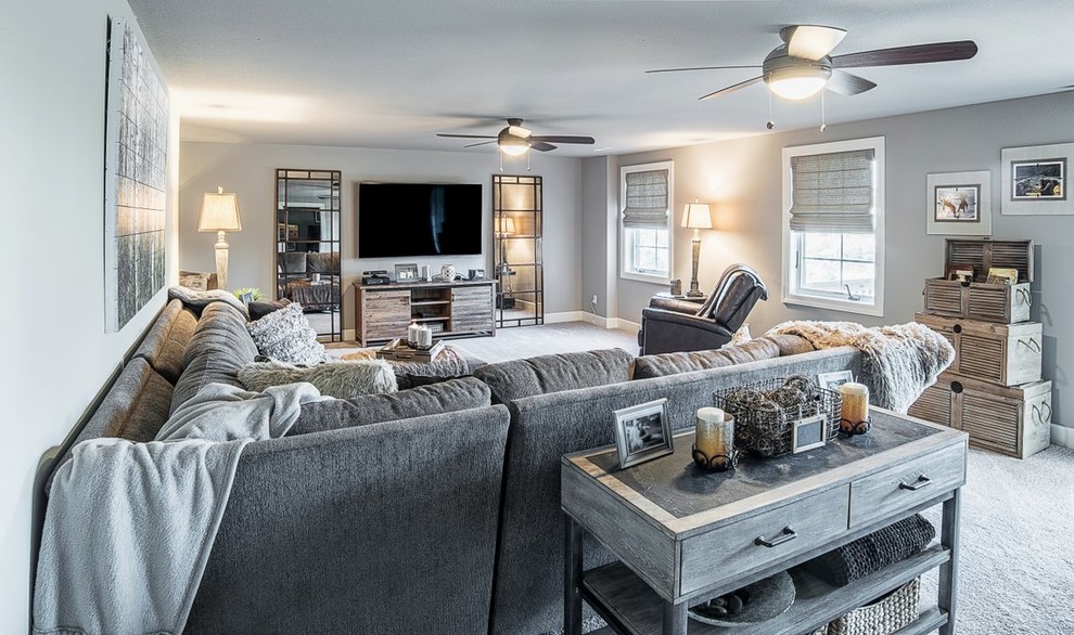 Ejemplo de sala de estar abierta tradicional renovada de tamaño medio sin chimenea con paredes grises, moqueta, televisor colgado en la pared y suelo gris