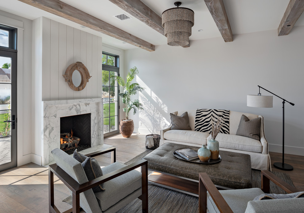 Foto de sala de estar campestre con paredes blancas, suelo de madera en tonos medios, todas las chimeneas, marco de chimenea de piedra, suelo marrón y alfombra