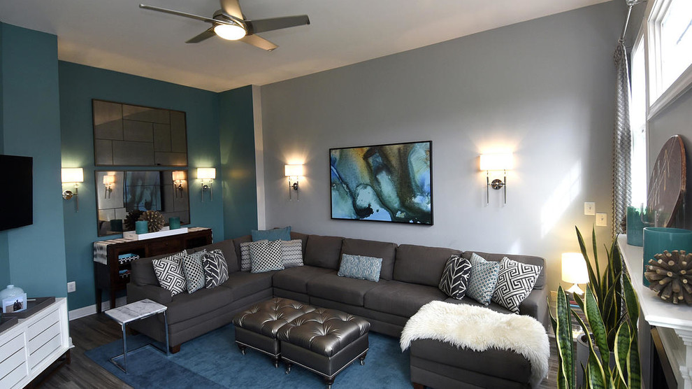 На фото: большая открытая гостиная комната в стиле неоклассика (современная классика) с серыми стенами, полом из винила, стандартным камином, фасадом камина из дерева и телевизором на стене