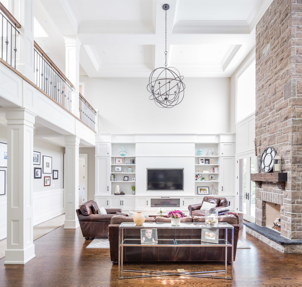 Huge transitional open concept dark wood floor family room photo in Toronto with gray walls, a standard fireplace, a stone fireplace and a media wall