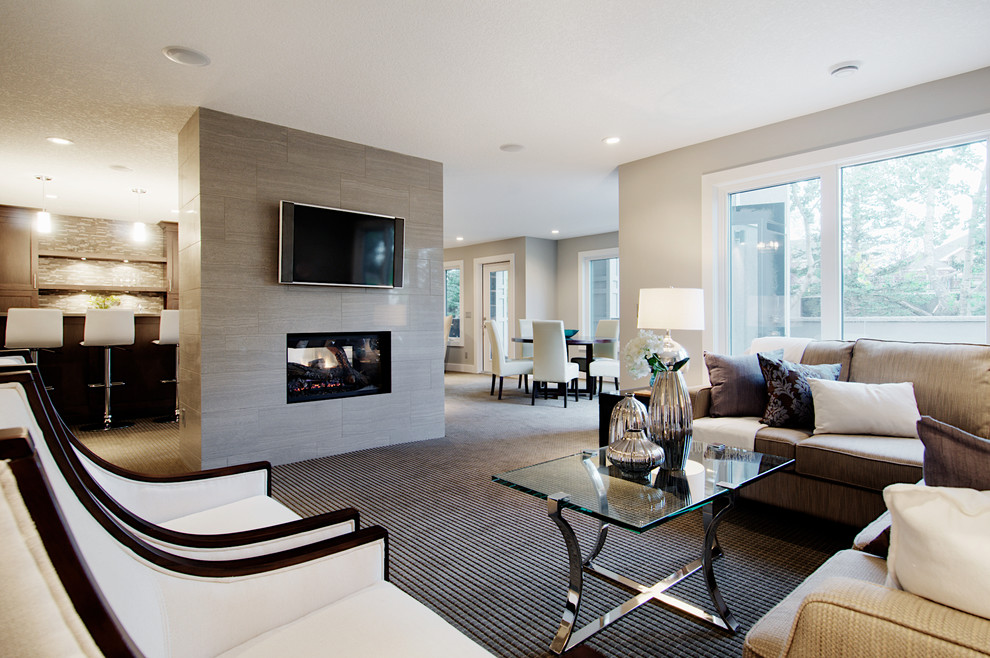 Ejemplo de sala de estar tradicional renovada con paredes grises, moqueta, chimenea de doble cara, marco de chimenea de baldosas y/o azulejos y televisor colgado en la pared