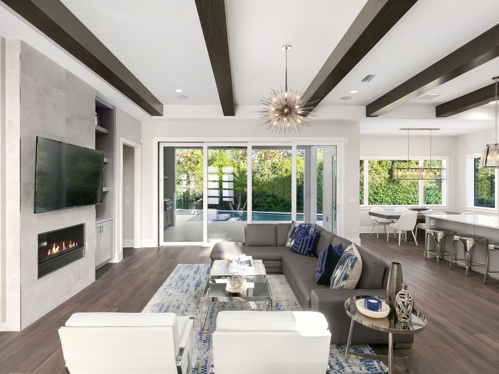Family room - mid-sized transitional open concept dark wood floor and brown floor family room idea in Orlando with gray walls, a stone fireplace, a wall-mounted tv and a ribbon fireplace