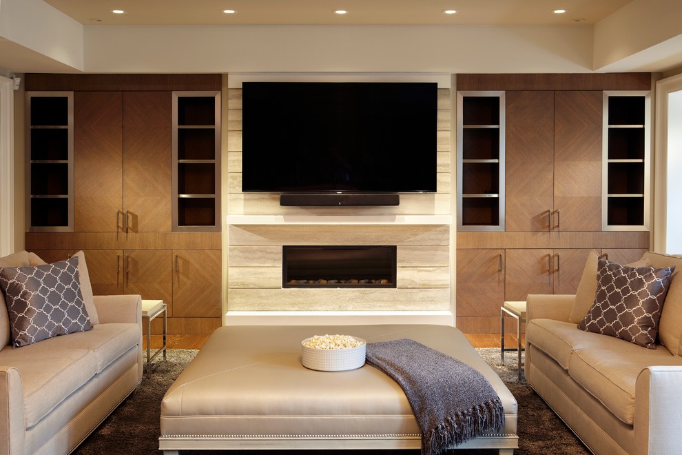 This is an example of a large traditional enclosed games room in Toronto with light hardwood flooring, a ribbon fireplace, a wall mounted tv and a tiled fireplace surround.