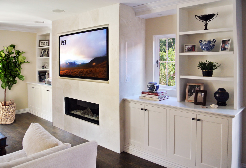 Diseño de sala de estar tradicional renovada de tamaño medio con paredes blancas, suelo de madera oscura, chimenea lineal y televisor colgado en la pared