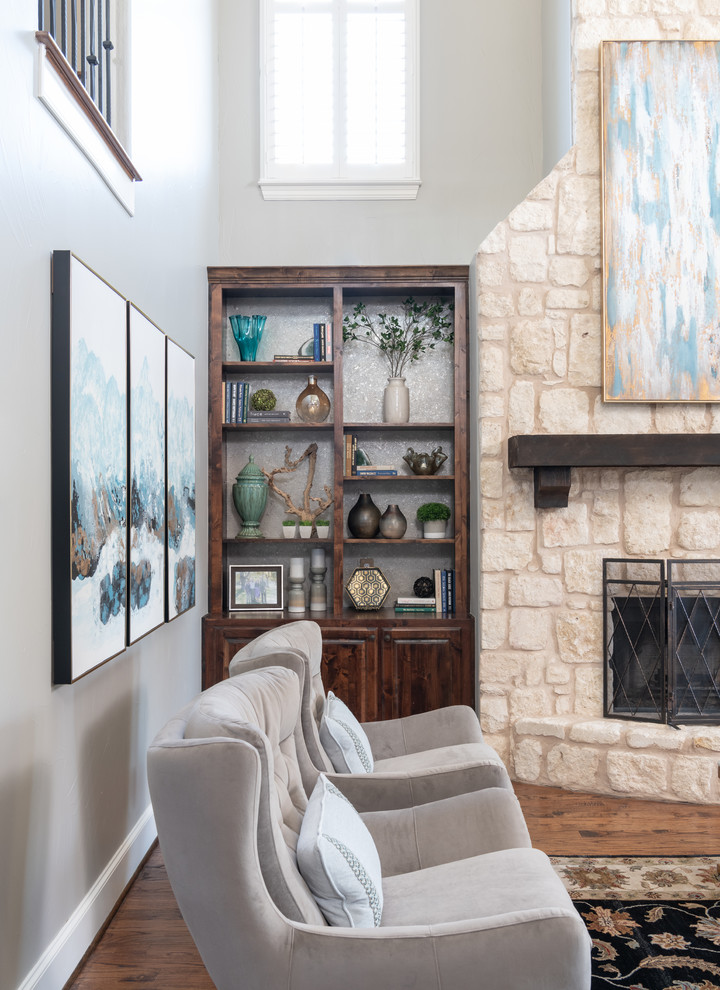 Example of a large transitional loft-style light wood floor and brown floor family room design in Dallas with gray walls, a standard fireplace and a stone fireplace