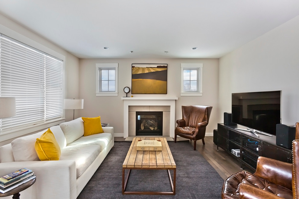 Imagen de sala de estar clásica renovada con paredes beige, suelo de madera en tonos medios, todas las chimeneas y televisor independiente