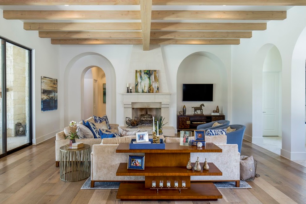 Foto de sala de estar clásica renovada con paredes blancas, suelo de madera clara, todas las chimeneas y televisor colgado en la pared