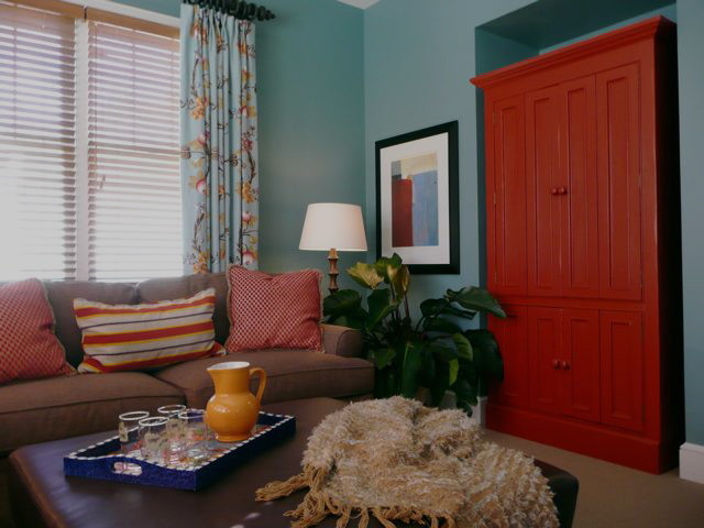 Cette image montre une salle de séjour traditionnelle de taille moyenne et fermée avec un mur bleu, moquette, aucune cheminée et un téléviseur dissimulé.