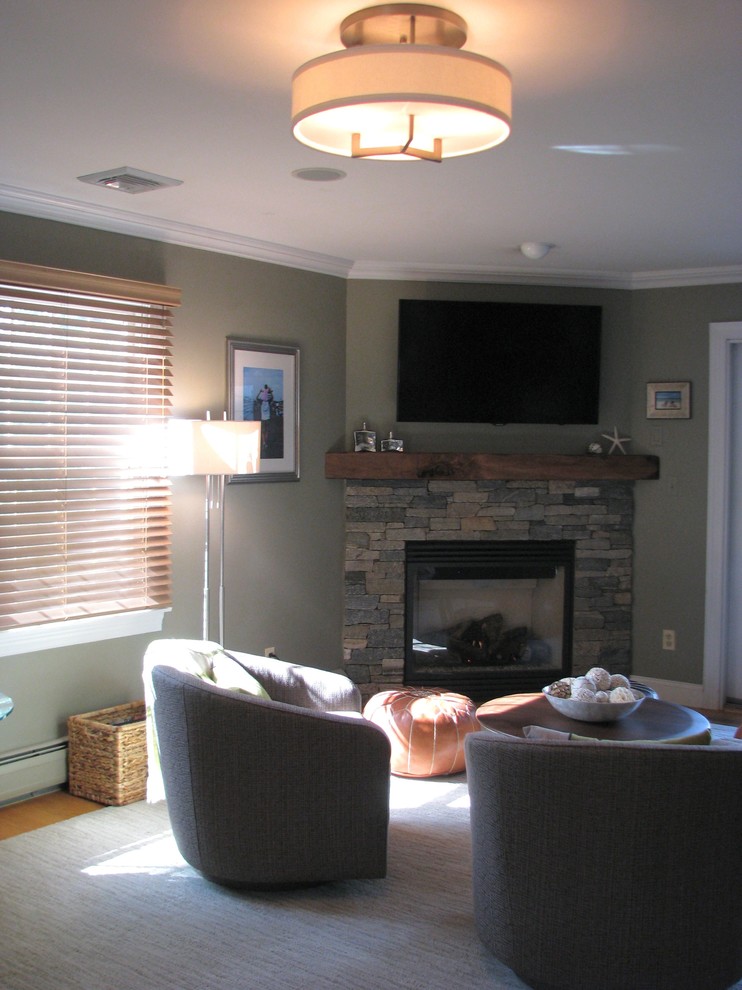 Immagine di un soggiorno classico di medie dimensioni con camino ad angolo, cornice del camino in pietra, TV a parete e pareti grigie
