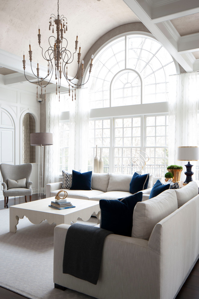 Modelo de sala de estar abierta y abovedada clásica renovada con paredes blancas, suelo de madera oscura, suelo marrón y panelado