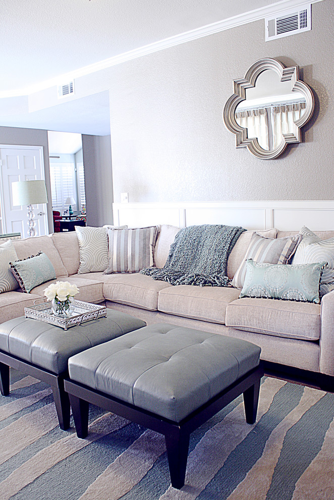 Ejemplo de sala de estar clásica renovada de tamaño medio con paredes beige, suelo laminado y televisor colgado en la pared