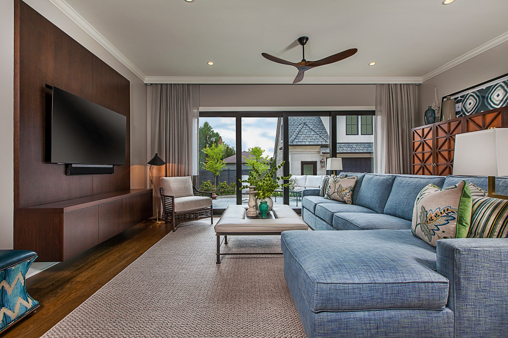 Modelo de sala de estar clásica renovada con suelo de madera oscura, televisor colgado en la pared, paredes grises y suelo marrón