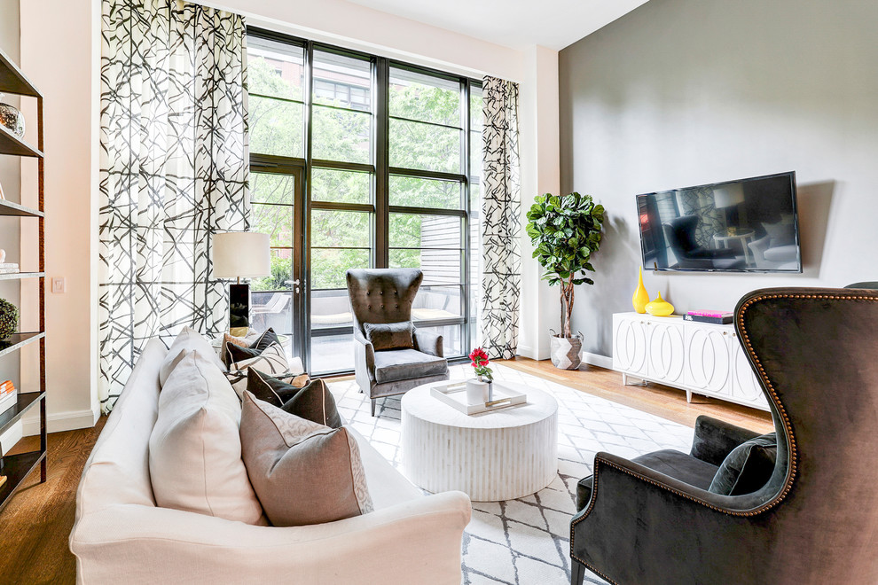 Источник вдохновения для домашнего уюта: гостиная комната в стиле неоклассика (современная классика) с серыми стенами, паркетным полом среднего тона и телевизором на стене без камина