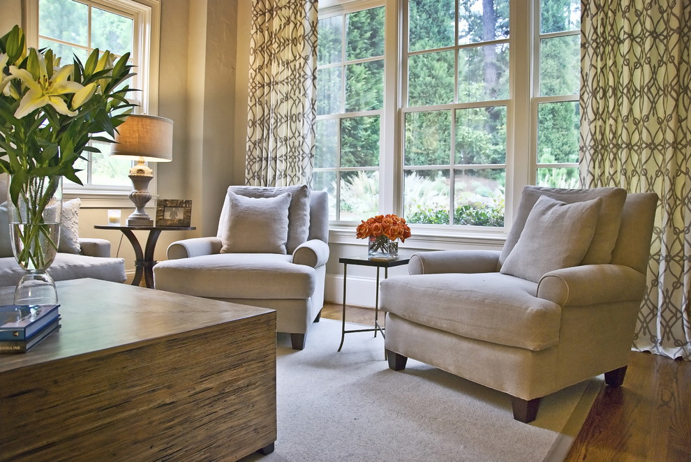 Modelo de sala de estar clásica renovada con paredes beige, suelo de madera en tonos medios y alfombra