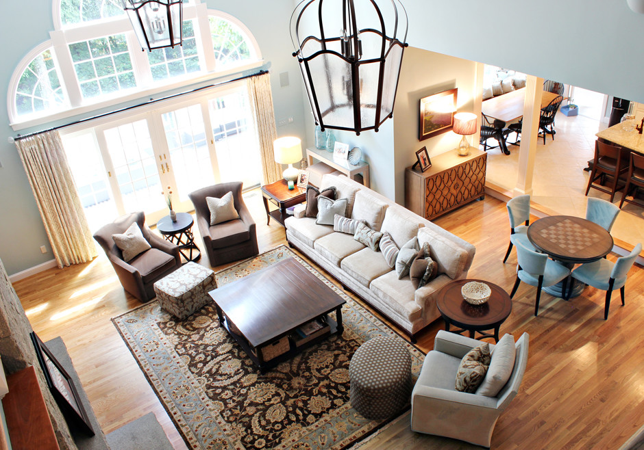 Foto de sala de estar con barra de bar abierta tradicional renovada extra grande con paredes azules, suelo de madera en tonos medios y marco de chimenea de piedra