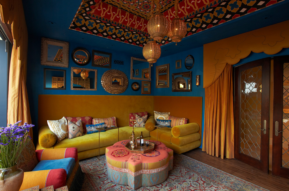 Modelo de sala de estar cerrada mediterránea sin chimenea y televisor con paredes azules y suelo de madera oscura