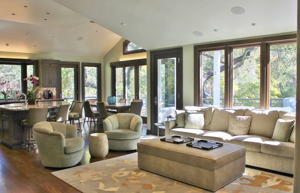 Diseño de sala de estar abierta tradicional renovada grande con paredes verdes, suelo de madera en tonos medios y televisor colgado en la pared