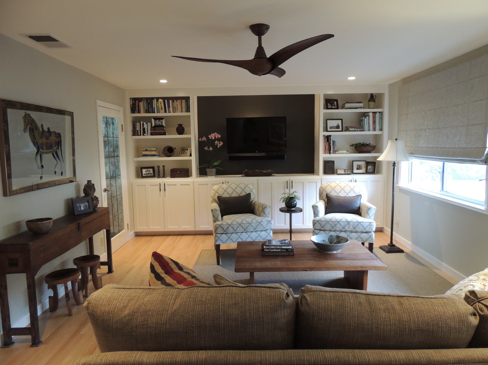 Imagen de sala de estar abierta clásica renovada de tamaño medio sin chimenea con paredes verdes, suelo de madera clara y pared multimedia