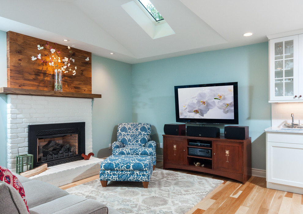 Ispirazione per un piccolo soggiorno tradizionale aperto con pareti blu, parquet chiaro, cornice del camino in mattoni e TV autoportante