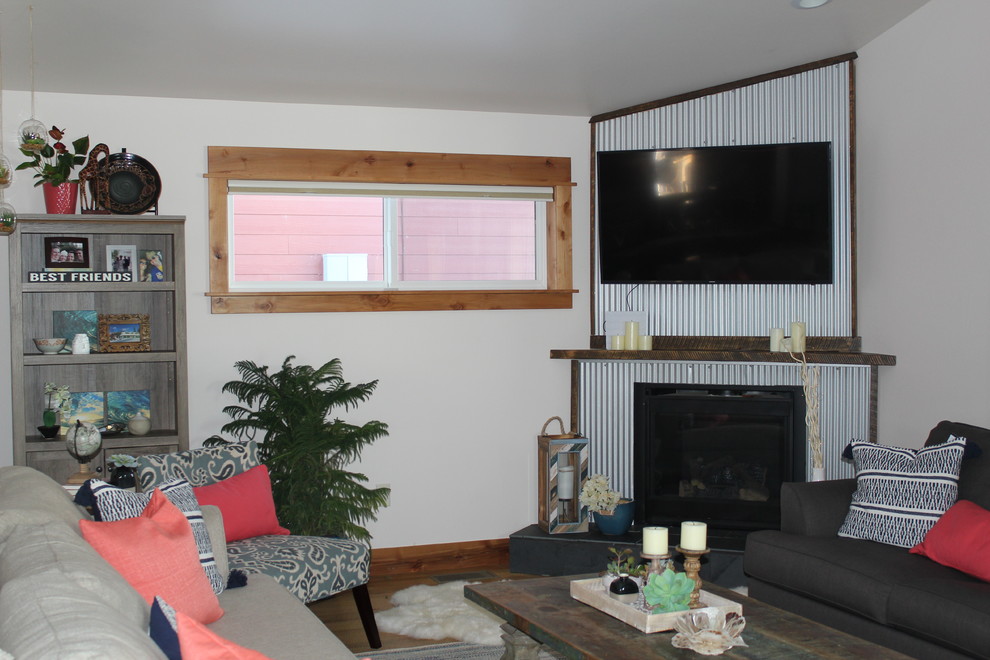他の地域にある中くらいなインダストリアルスタイルのおしゃれなオープンリビング (白い壁、濃色無垢フローリング、コーナー設置型暖炉、金属の暖炉まわり、壁掛け型テレビ、茶色い床) の写真