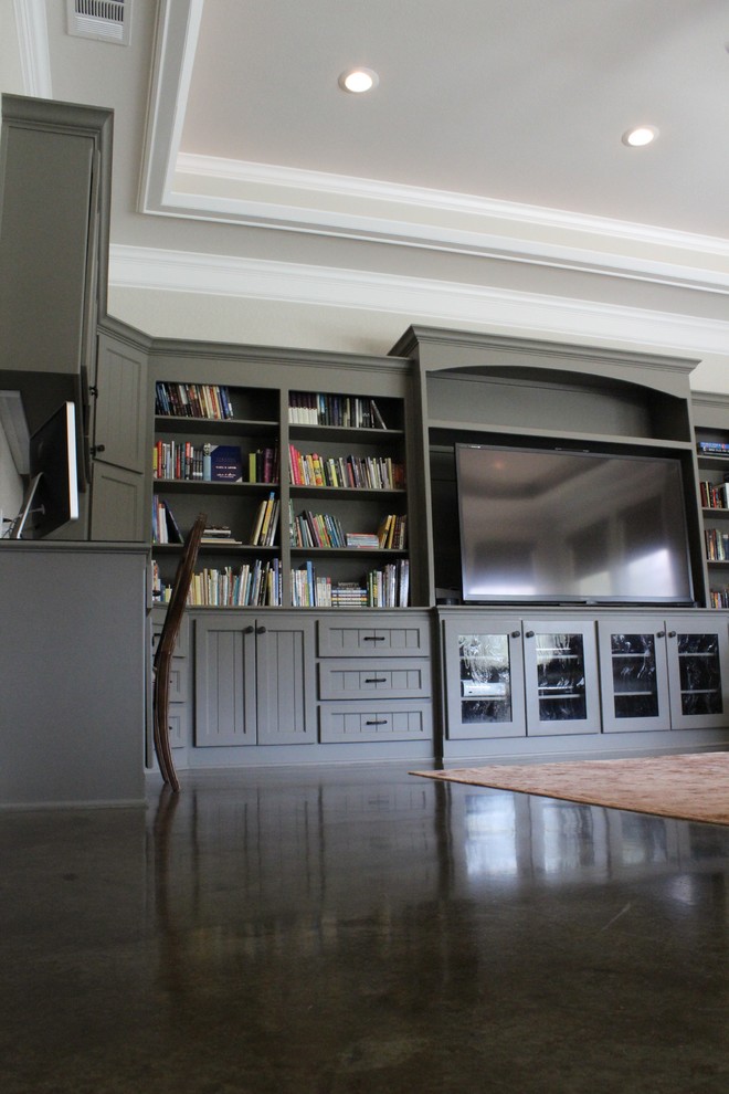 Large transitional open concept concrete floor family room photo in Austin with gray walls and a media wall