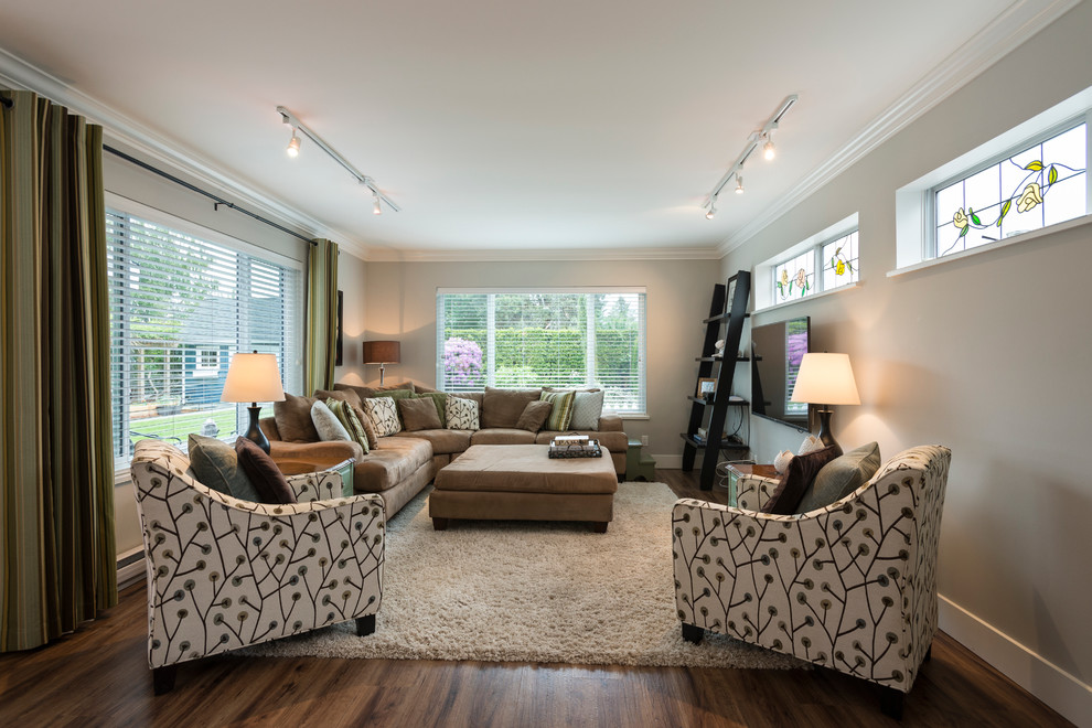 Diseño de sala de estar abierta clásica renovada de tamaño medio sin chimenea con paredes grises, suelo de madera en tonos medios y televisor colgado en la pared