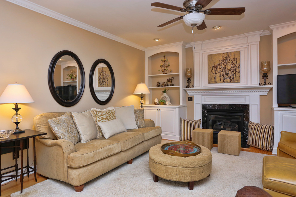 Medium sized classic open plan games room in Raleigh with beige walls, medium hardwood flooring, a standard fireplace, a wooden fireplace surround, a corner tv and brown floors.