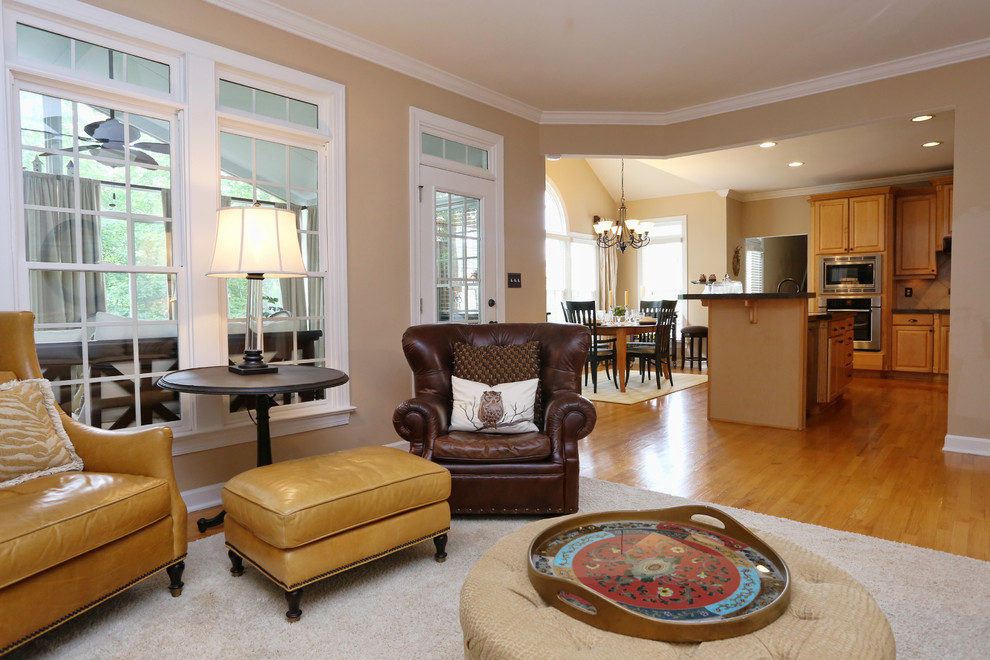 Mittelgroßes, Offenes Klassisches Wohnzimmer mit Eck-TV, beiger Wandfarbe, braunem Holzboden, Kamin, Kaminumrandung aus Holz und braunem Boden in Raleigh