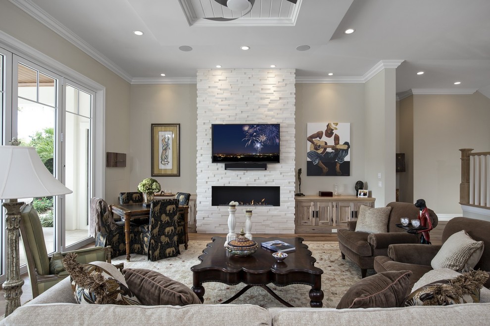 Diseño de sala de estar tradicional con paredes beige, chimenea lineal y televisor colgado en la pared