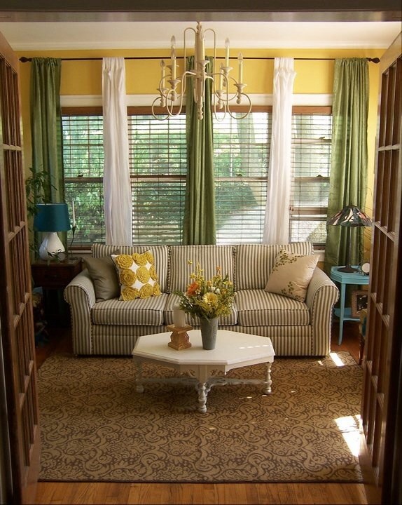 Diseño de sala de estar clásica de tamaño medio sin chimenea con paredes amarillas y suelo de madera en tonos medios