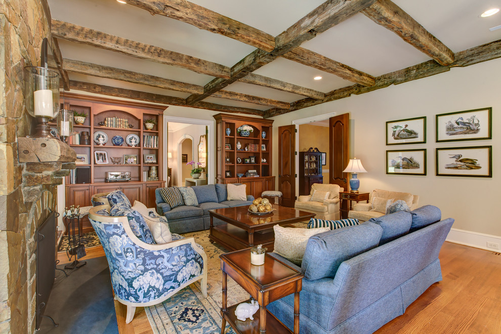 Ejemplo de sala de estar abierta clásica grande con paredes beige, suelo de madera clara, todas las chimeneas, marco de chimenea de piedra y televisor colgado en la pared