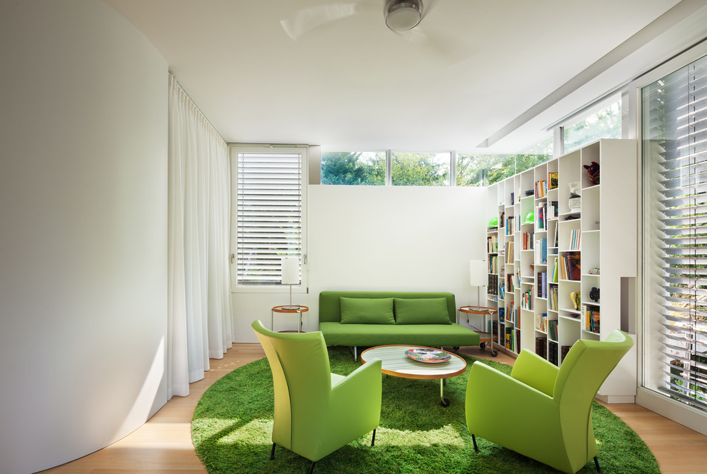 Exemple d'une salle de séjour tendance de taille moyenne avec une bibliothèque ou un coin lecture, un mur blanc, un sol en bois brun et un sol beige.