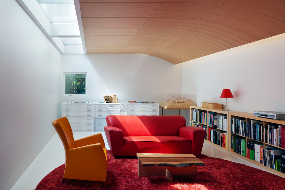 Exemple d'une salle de séjour tendance de taille moyenne avec une bibliothèque ou un coin lecture, un mur blanc et sol en béton ciré.