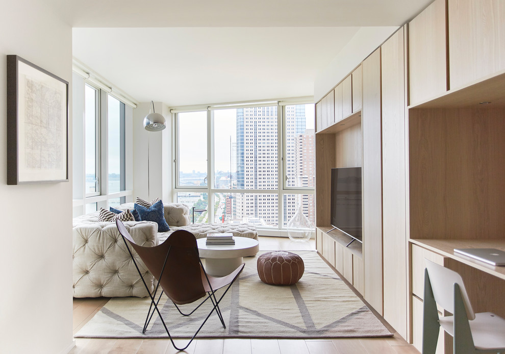 Foto di un soggiorno design con pareti bianche, parquet chiaro, TV autoportante e pavimento beige