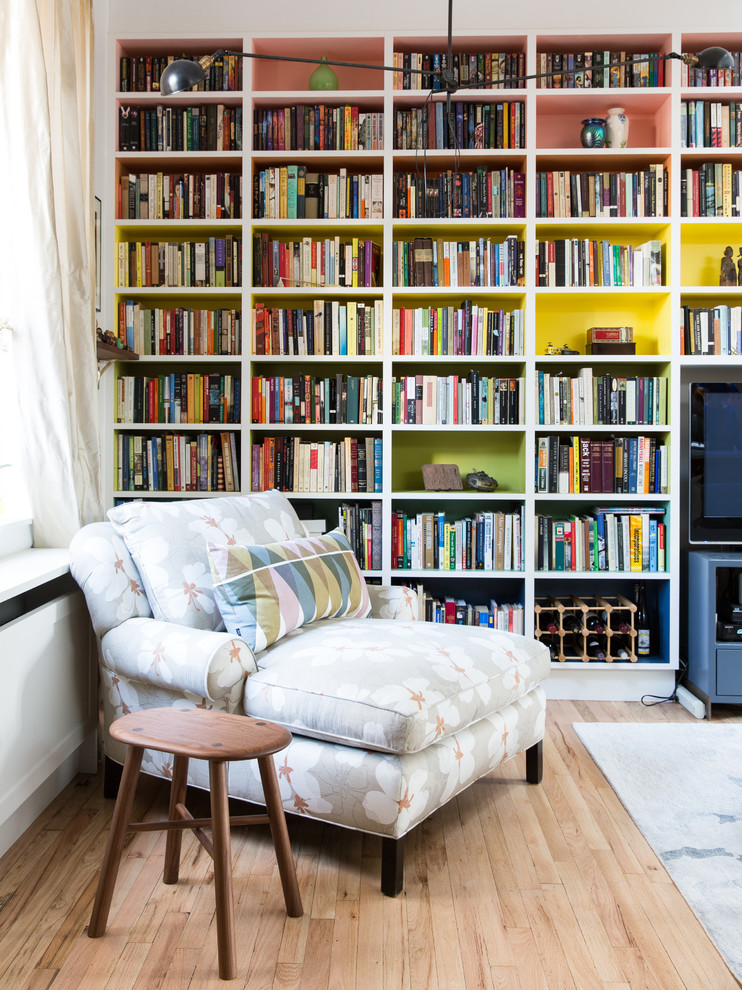 Exemple d'une salle de séjour ouverte avec une bibliothèque ou un coin lecture et parquet clair.