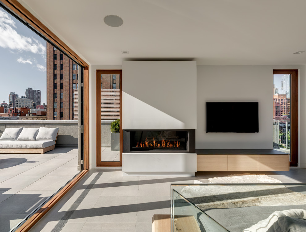 Cette image montre une salle de séjour minimaliste ouverte avec une cheminée ribbon et un téléviseur fixé au mur.