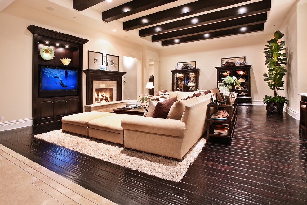 Photo of an expansive mediterranean open plan games room in Orange County with beige walls, dark hardwood flooring and a standard fireplace.
