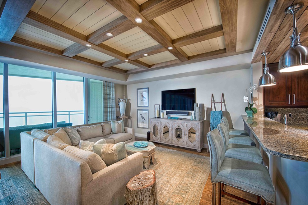 Foto de sala de estar abierta tropical de tamaño medio sin chimenea con suelo de madera en tonos medios, paredes blancas, televisor independiente y suelo marrón