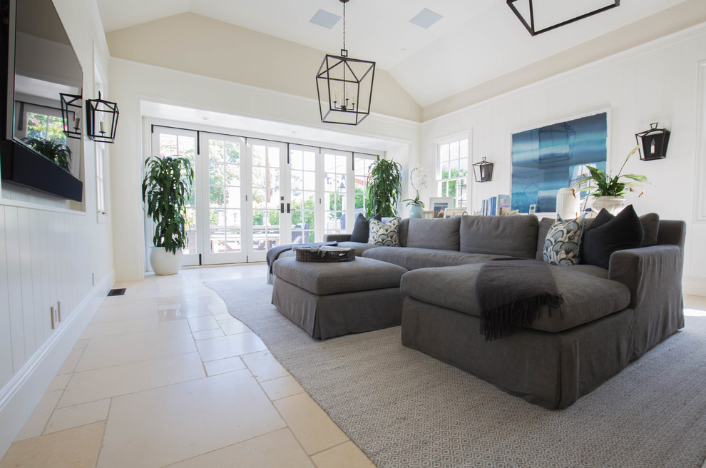 サンディエゴにあるお手頃価格の広いトランジショナルスタイルのおしゃれなオープンリビング (ホームバー、白い壁、ライムストーンの床、暖炉なし、壁掛け型テレビ) の写真